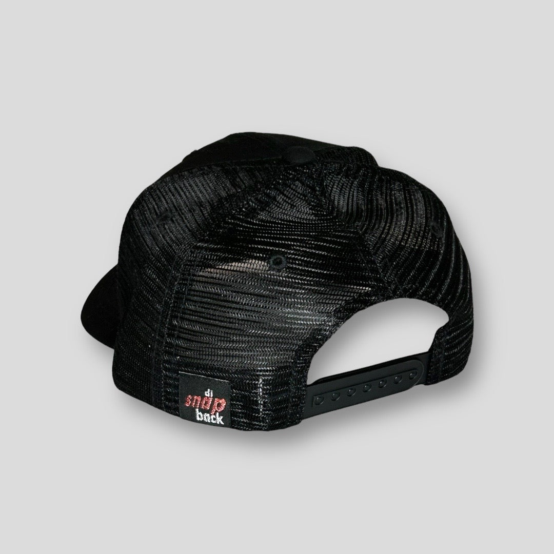 This image is the back of a snapback hat. It is a black mesh with Di Snap Back Label sewn into the back of the hat.