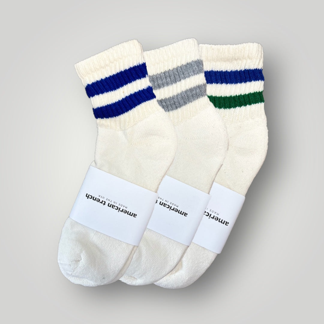 Three quarter length men's socks in natural cotton color. The bundle includes a blue double stripe sock, a grey double stripe sock, and a retro inspired blue and green stripe sock. The stripes are each located one the cuff of the sock. The footbed has extra cushion.