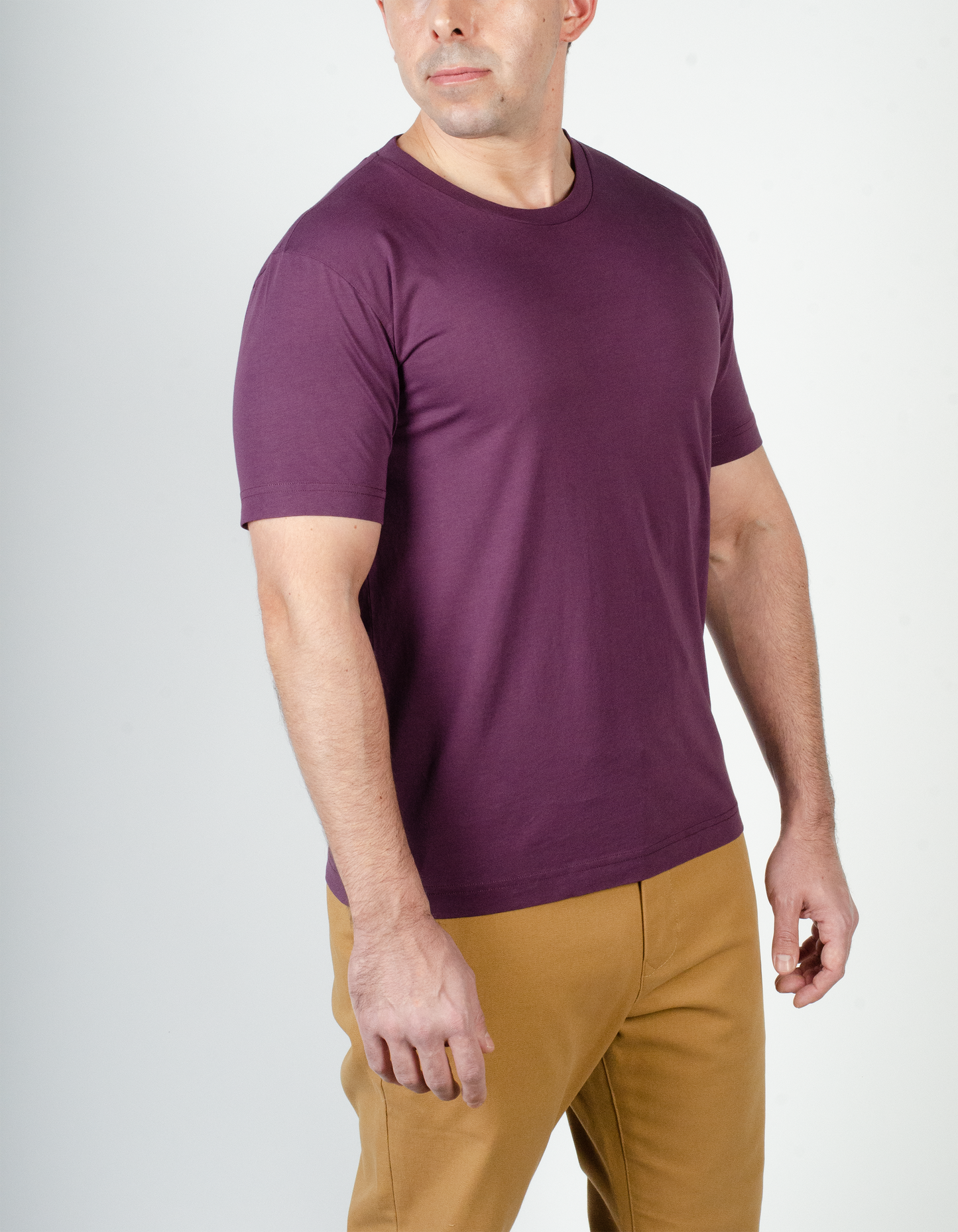 The model is wearing the size medium Essential tee in light aubergine.