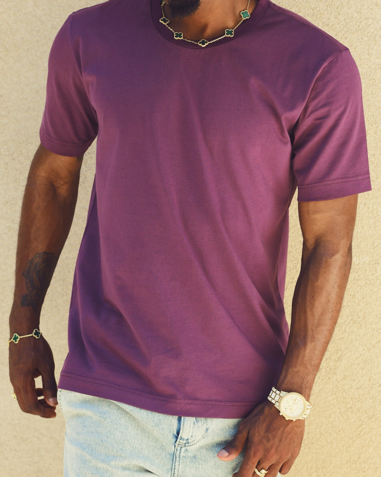 The model is wearing a size medium essential tee in the color light aubergine.  It is a crew neck, short sleeve t-shirt for men, sized for guys 5'8" and under. 